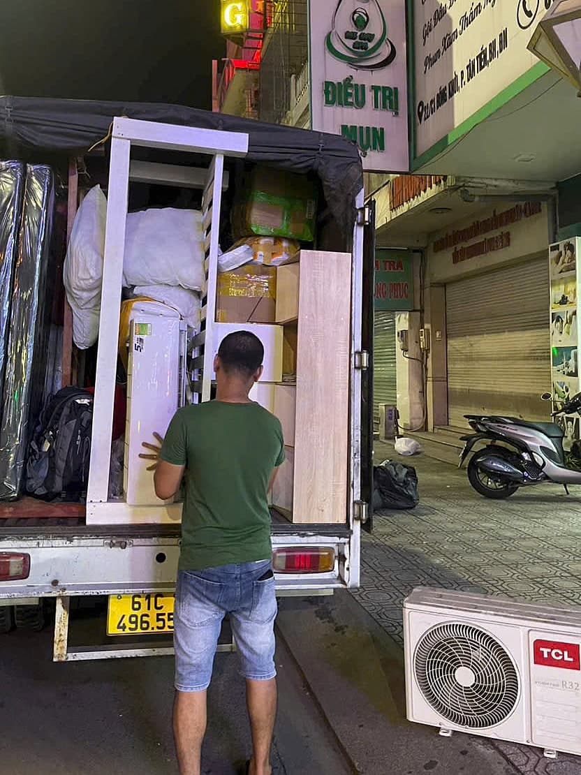 Xe tải chất đầy đồ, bên cạnh là cục nóng máy lạnh đã tháo