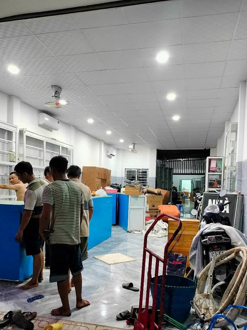 Đội chuyển trọ dọn đồ bên trong nhà khách, có xe đẩy hàng