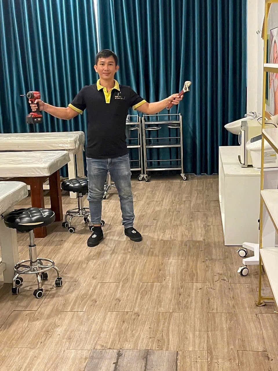 Thợ máy lạnh cầm máy khoan và mỏ lết